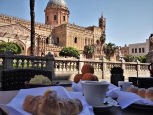 una mesa con pastas y café y un edificio en I Vicini della Cattedrale, en Palermo