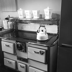 a tea kettle is sitting on top of an oven at La maison du Lac in Spa