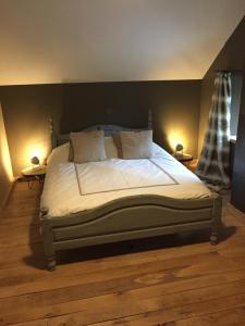 a large bed in a bedroom with two lamps at La maison du Lac in Spa