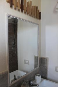 uma casa de banho com um espelho grande sobre um lavatório em B&B S'arenada em Ghilarza