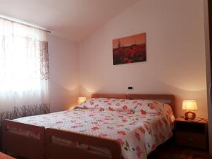 a bedroom with a bed with a floral bedspread at Kuća za odmor - apartman Vito in Valtura