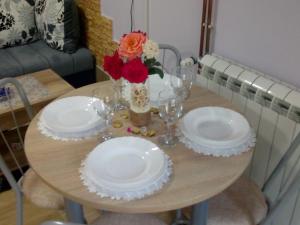 a table with plates and glasses and flowers on it at Gorica in Vrdnik
