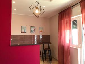 a kitchen with a bar and a red wall at Apartment Antonella in Ostuni