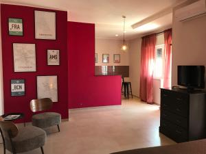 a living room with a red wall and a tv at Apartment Antonella in Ostuni