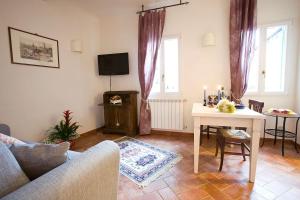 uma sala de estar com uma mesa e uma televisão em Ellen's cozy apartment em Florença