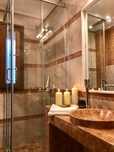 a bathroom with a sink and a shower with candles at Xenonas Iresioni in Arachova