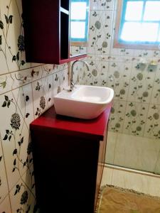 a bathroom with a white sink on a red counter at Residencial Saldanha in Gramado +67 photos