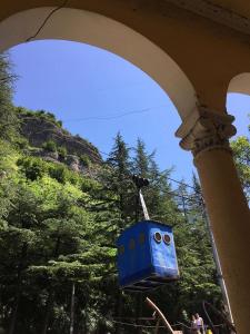 a blue train is hanging from a building at hotel in chiatura in Chiatʼura