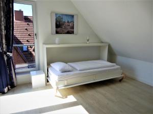 ティメンドルファー・シュトラントにあるExklusive familienfreundliche Ferienwohnung im Haus Aalbeekの窓付きの客室の小さなベッド1台分です。