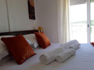 a bedroom with two beds with orange and white pillows at Casa Dorita in Odeceixe