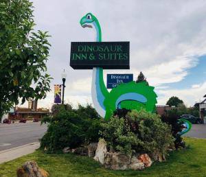 a sign for a dinosaur inn and suites at Dinosaur Inn & Suites in Vernal