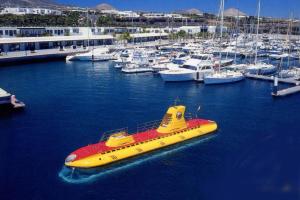 a yellow and red boat in a marina with boats at Casa Zen in Puerto Calero