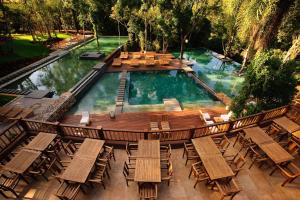 Una vista aérea de una piscina con sillas y una terraza. en Loi Suites Iguazu Hotel, en Puerto Iguazú