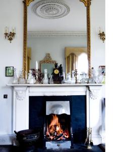 a fireplace in a living room with a mirror at Rossnaree House in Slane