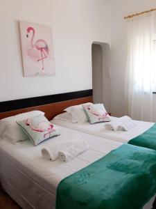 Dos camas en una habitación de hotel con toallas. en Casa Dorita en Odeceixe
