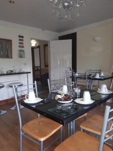 uma sala de jantar com uma mesa preta e cadeiras em GoldenDawn Guest House em Citywest