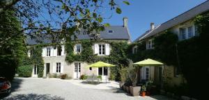 uma casa com dois guarda-chuvas em frente em Liz'A logis de Charme em Saint-Côme-de-Fresné