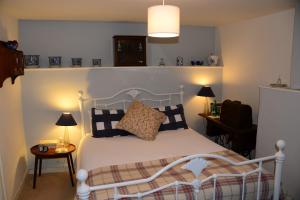 a bedroom with a white bed with pillows on it at Middle Farm Cottage in Wells