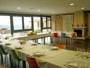 un comedor con mesas y sillas y copas de vino en Alberjerte, en El Torno