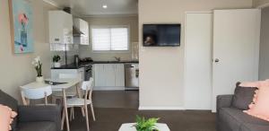 a kitchen and living room with a couch and a table at Rose Apartments Unit 3 Central Rotorua - Accommodation & Spa in Rotorua