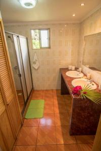 a bathroom with a double sink and a shower at Cabañas Henua Iti in Hanga Roa