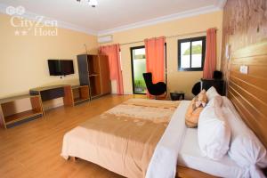 a hotel room with a bed and a television at Cityzen Hotel in Douala