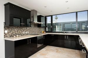 a kitchen with black cabinets and a large window at Staycity Aparthotels Liverpool City Centre in Liverpool