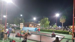 a crowd of people standing around a tennis court at night at Tower of the Bear Flat in Torre dell'Orso
