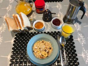 una mesa con un plato de cereales, tostadas y zumo de naranja en Languor B&B en Carterton