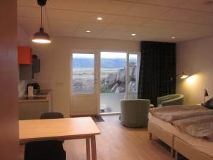 a bedroom with a bed and a table and a window at Apartment Brekka í Lóni in Stafafell