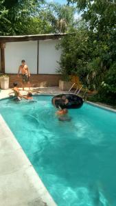 um grupo de pessoas a nadar numa piscina em Aimara apartamentos y habitaciones em Santa Rosa de Calamuchita