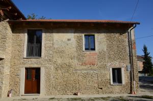 a brick house with two windows and a door at cascina Filura in Mango