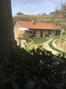 a house with a red roof and a yard at cascina Filura in Mango