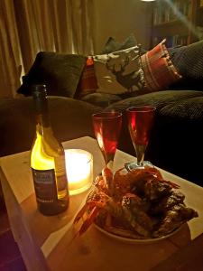 a table with a plate of lobster and a bottle of wine at The Herring Queen in Eyemouth