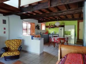 a kitchen and living room with a table and chairs at La Maison de Thelma in Bézues-Bajon