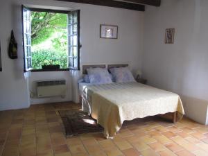 a bedroom with a bed and a large window at Cottage Poppy in Tursac