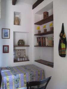 a bedroom with a table and a chair and shelves at Cottage Poppy in Tursac