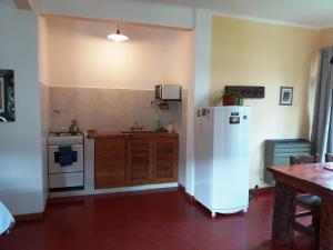a kitchen with a white refrigerator and a stove at El Portal del Lago in Lago Puelo