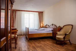 ズノイモにあるAlthanský palácのベッドルーム1室(ベッド1台、椅子、窓付)