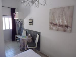 a dining room with a table and a painting on the wall at City Center Room Olivia in Hvar