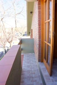 - une terrasse couverte avec des bancs et une fenêtre sur un bâtiment dans l'établissement Apartamento Lencinas, à San Rafael