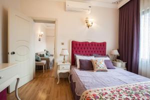 1 dormitorio con 1 cama grande y cabecero rojo en Olive Garden Suite Hotel, en Estambul