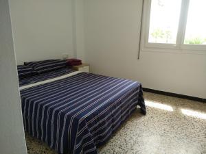 カンブリルスにあるCambrils Playaのベッドルーム1室(青と白のストライプの毛布付きのベッド1台付)