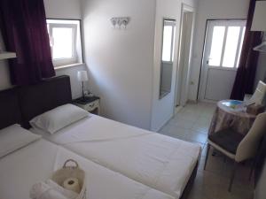 a bedroom with a white bed and a chair at City Center Room Olivia in Hvar +13 photos