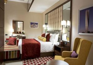 アブジャにあるThe Envoy Hotel Abujaのベッドと椅子付きのホテルルーム