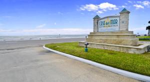 a sign at the beach with the ocean in the background at Casa Del Mar - Ocean View in Galveston