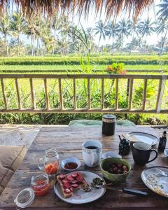 een houten tafel met borden met eten erop bij Les Rizieres Lombok - Tetebatu in Tetebatu