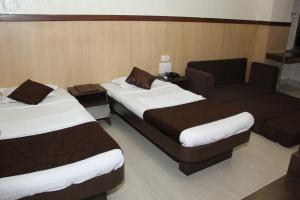a hotel room with two beds and a couch at Hotel Ripon Palace in Mumbai +30 photos