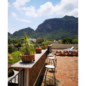 een balkon met stoelen en potplanten en een berg bij La Casa del Volcan in Tlayacapan