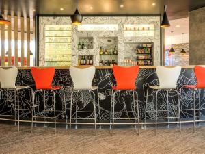 eine Bar mit roten Stühlen in einem Restaurant in der Unterkunft Ibis Mexico Perinorte in Mexiko-Stadt